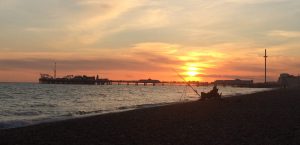 A man fishing during the sunset over Brighton beach