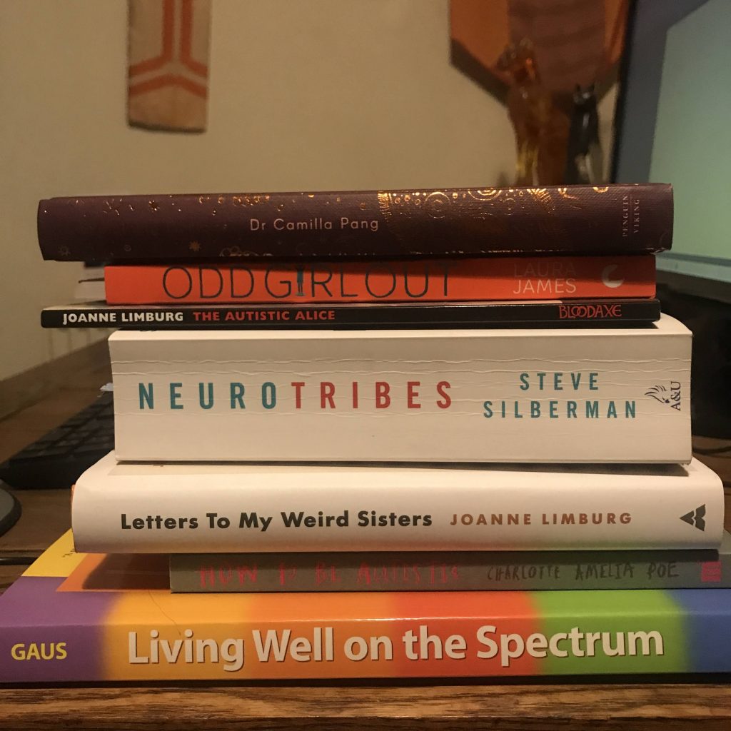 A pile of books about autism, many about autism in women. 