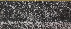 Snow on a railway platform and the raised edge near the track.
