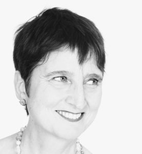 Black and white photo of Naomi Foyle, a smiling middle-aged white woman.