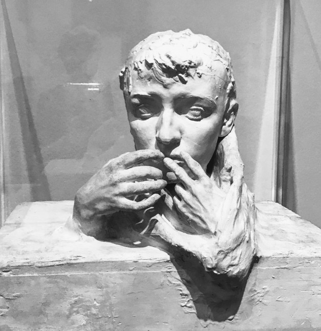 A sculpture by Rodin - a plaster cast of Camille Claudel's head, with two hands emerging from the base to cover her lips